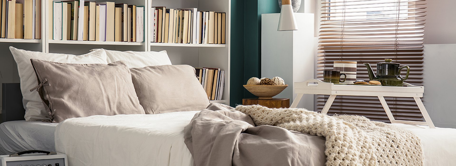 Creative use of small space in a stylish bedroom interior with designer decor and cozy white and beige bedding