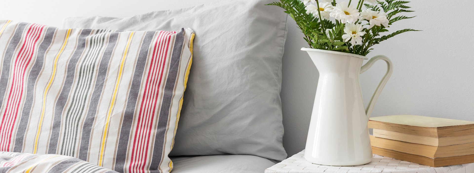 White flowers and books on a bedside table